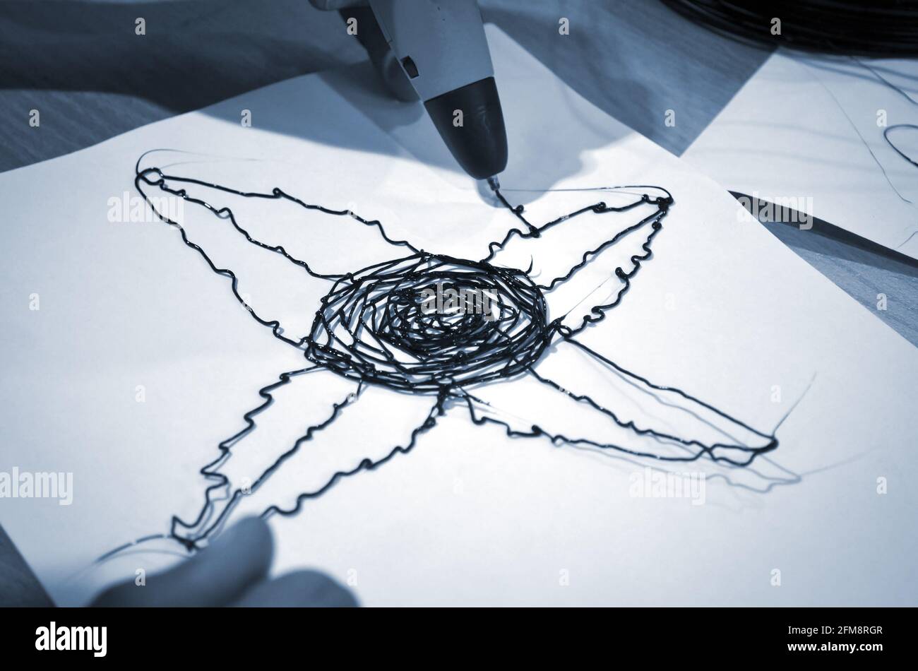 Man 3d Pen zeichnet eine Blume auf weißes Papier Stockfoto