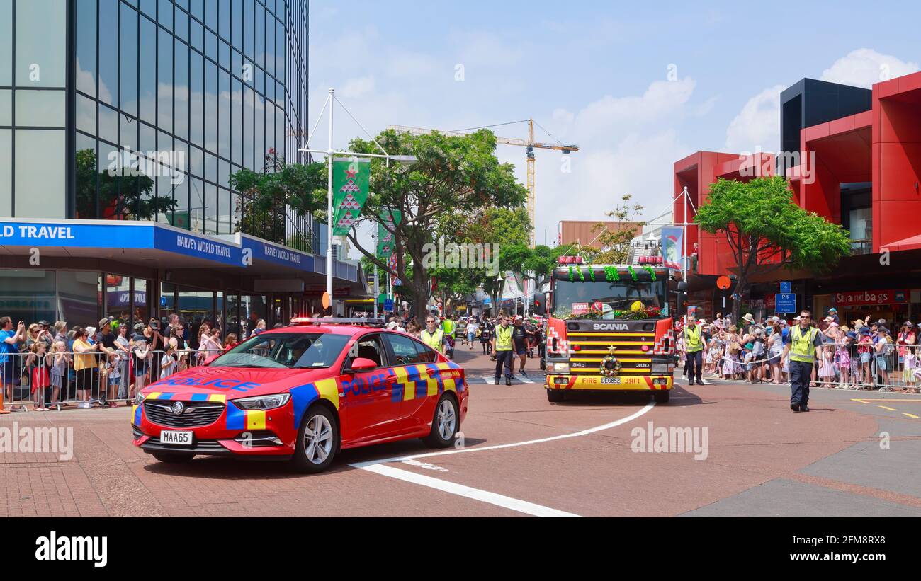 Ein neuseeländischer Polizeiwagen begleitet einen dekorierten Feuerwehrwagen bei einer Weihnachtsparade in Tauranga, Neuseeland Stockfoto