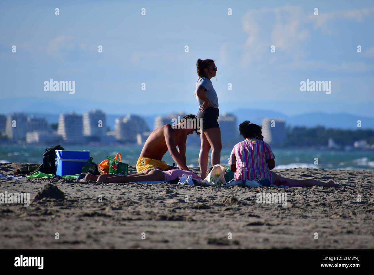 Familienpicknicken am Sandstrand von Port Camargue, in der Nähe von La Grande Motte und Montpellier, in der Nähe von Les Ciscitanie, Südfrankreich Stockfoto