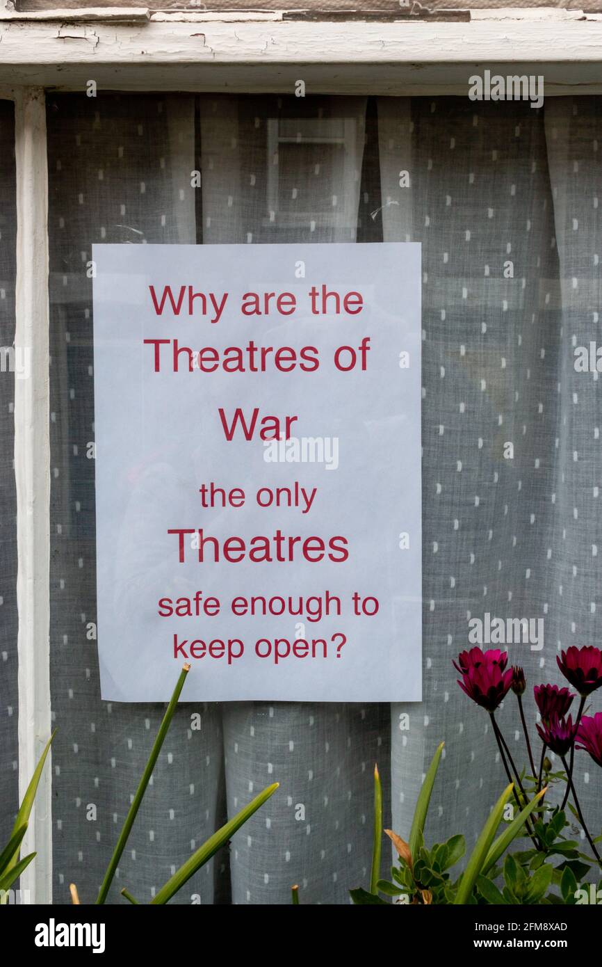 Ein Plakat fragt, warum die Theater wegen der Beschränkungen von Covid-19 immer noch geschlossen sind, aber Kriege können immer noch andauern. Cambridge, Großbritannien. Stockfoto