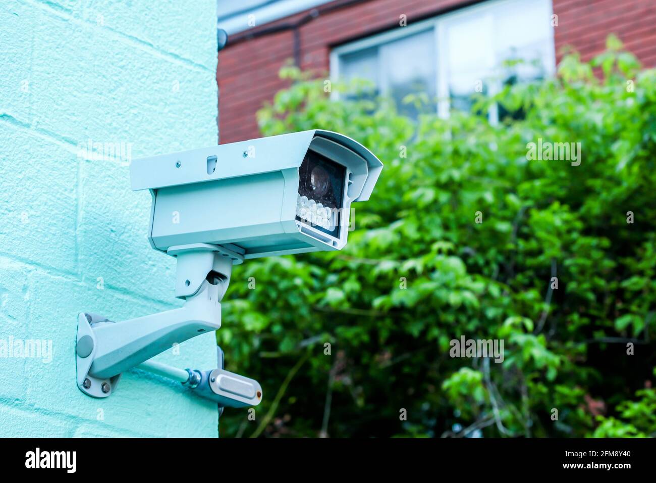 Überwachungskamera auf Gebäude mit blauem Himmel Stockfoto