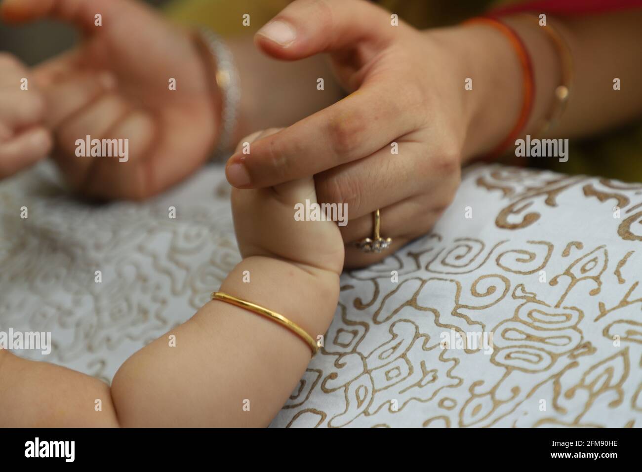 Nahaufnahme einer Mutter, die die Hand ihres neugeborenen Kindes hält Ein unscharfer Hintergrund Stockfoto