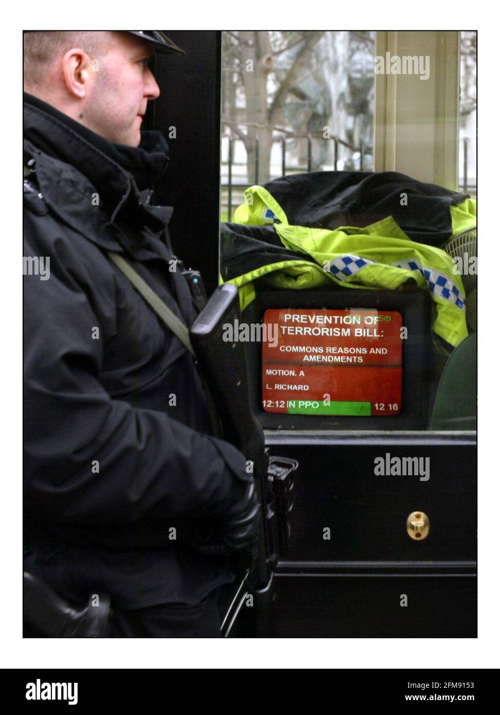 Bewaffnete Polizisten stehen Wache vor dem Unterhaus A Der TV-Bildschirm aktualisiert die Sicherheit, während die Anti-Terrorismus-Gesetzgebung diskutiert wird Im parlament in London.pic David Sandison 11/3/2004 Stockfoto