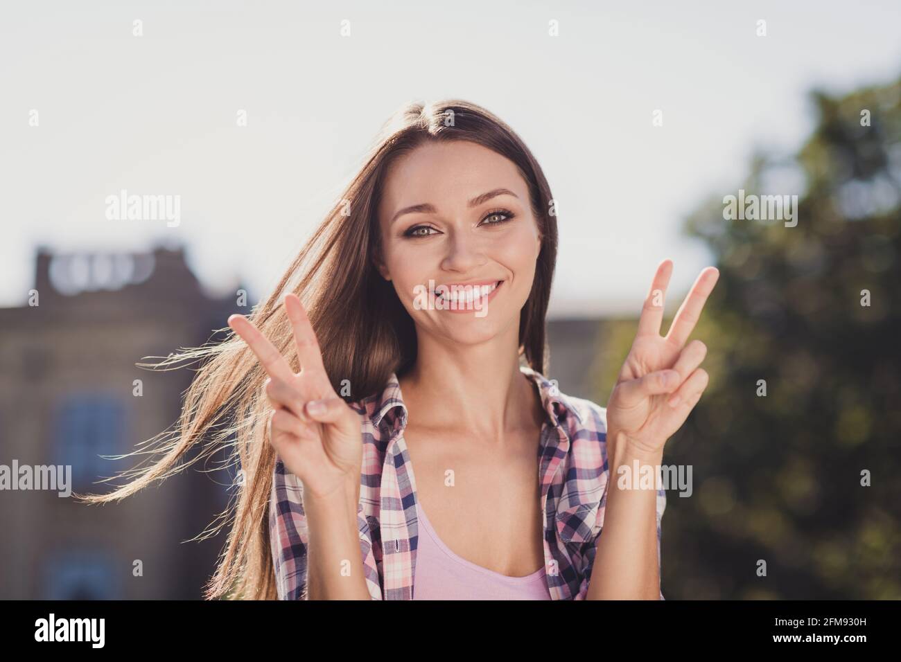 Foto von glücklich Brünette haarige Frau machen V-Zeichen Gruß Universität Schüler draußen im Park draußen Stockfoto