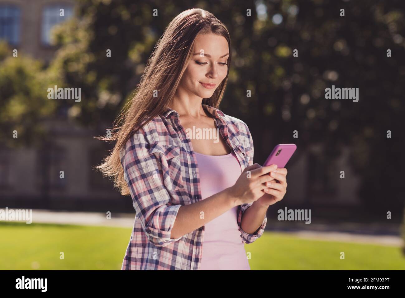Foto von jungen Frau glücklich positive Lächeln suchen Handy durchsuchen Chat-Typ sms Wochenende Park Universität Campus im Freien Stockfoto