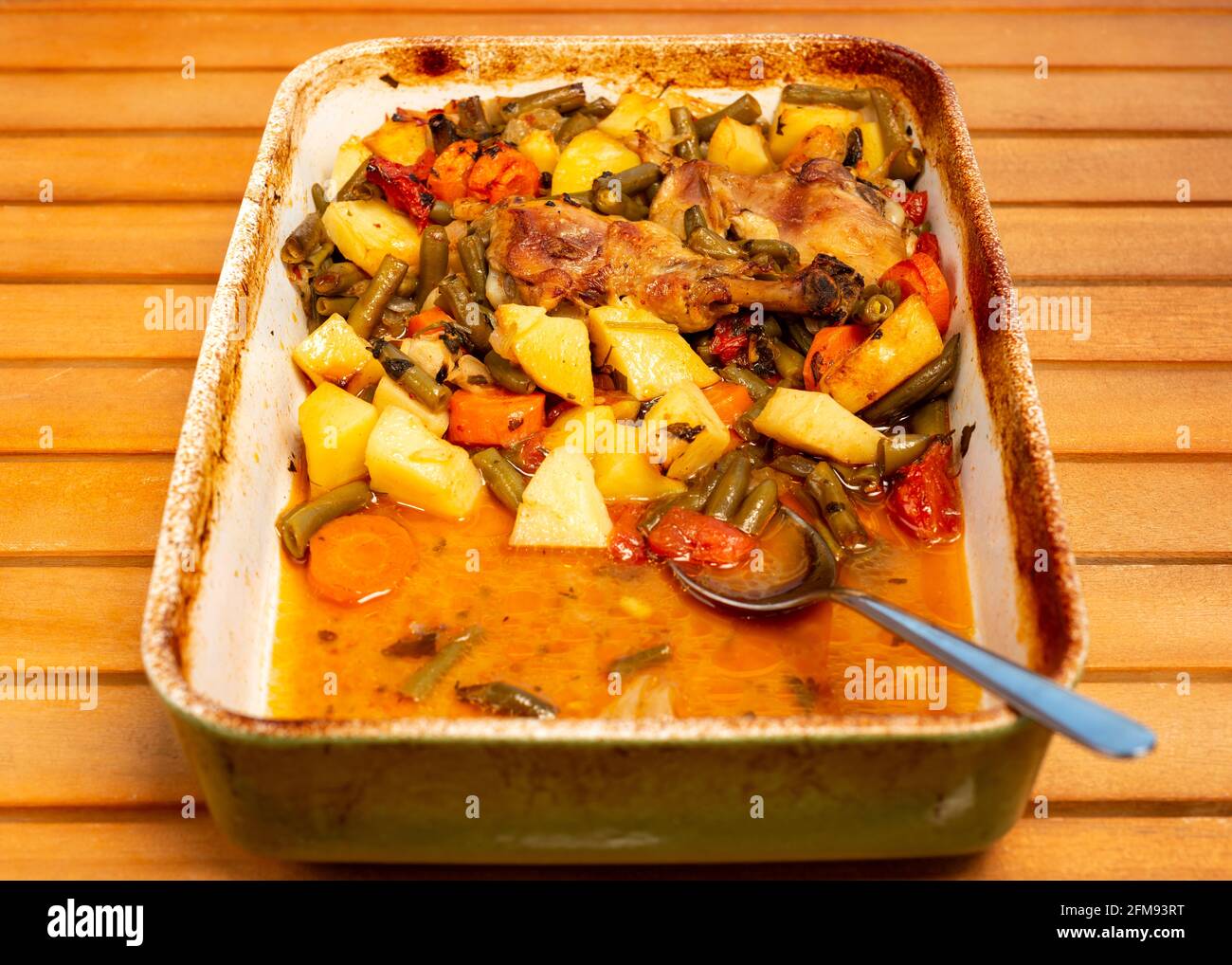 Die Hälfte der Hähncheneintopf mit Gemüse in Keramik Braten Schwenken Stockfoto