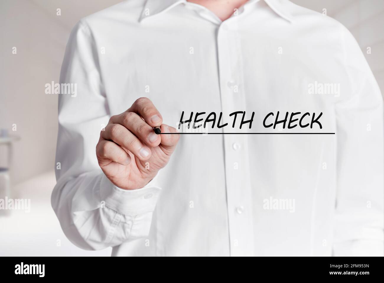 Mann mit Stift unterstreicht die Worte Health Check auf einem virtuellen Bildschirm. Stockfoto