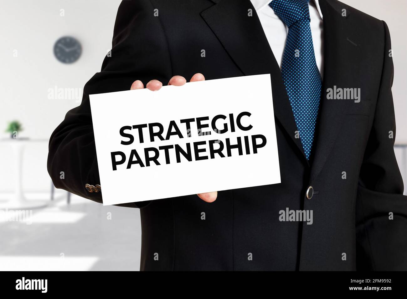 Geschäftsmann hält eine Karte mit der Botschaft strategische Partnerschaft. Geschäftskonzept. Stockfoto