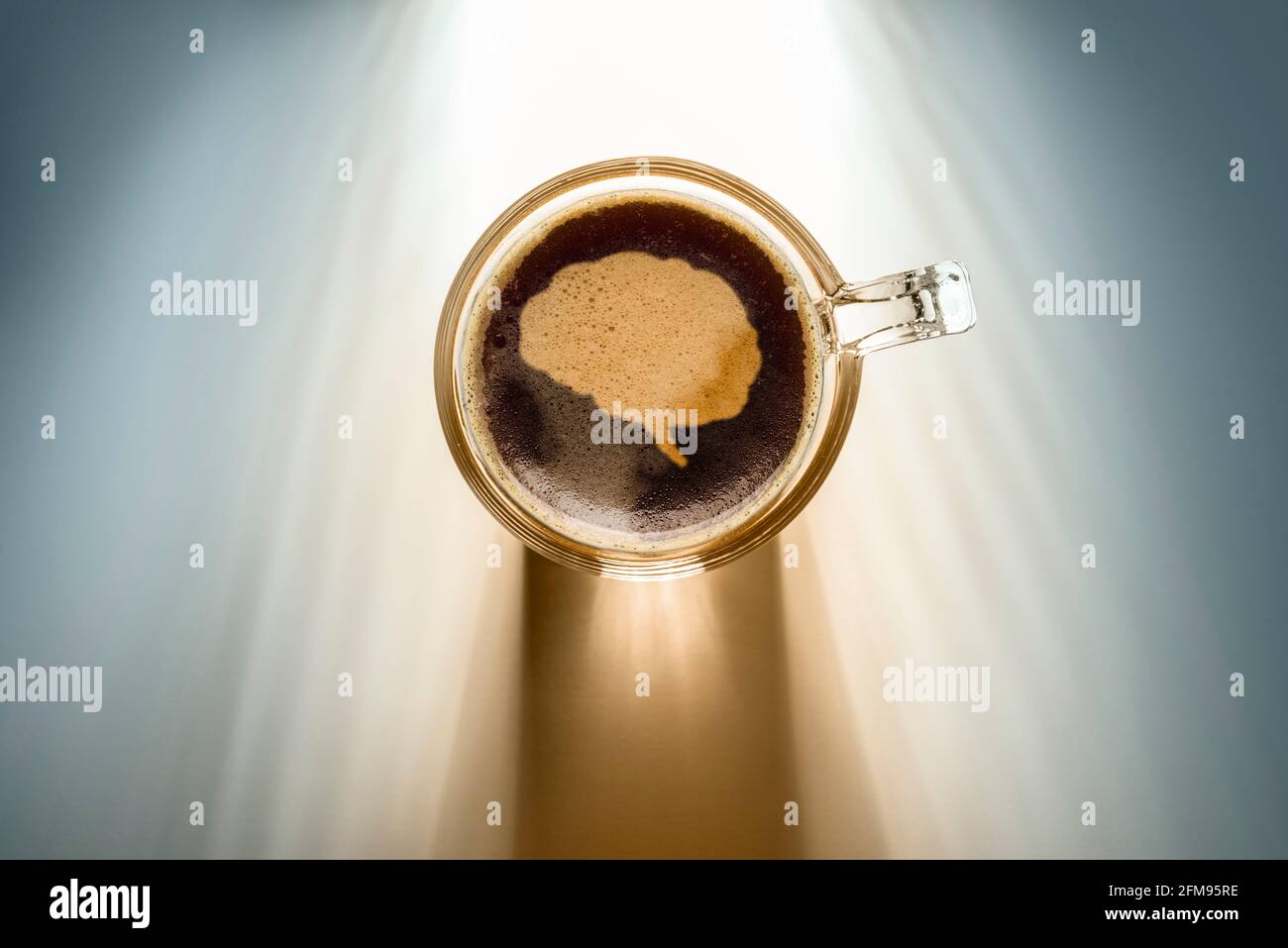 Kaffeetasse mit Hirn-Symbol, Draufsicht auf dem Hintergrund mit Sonnenlicht. Stockfoto