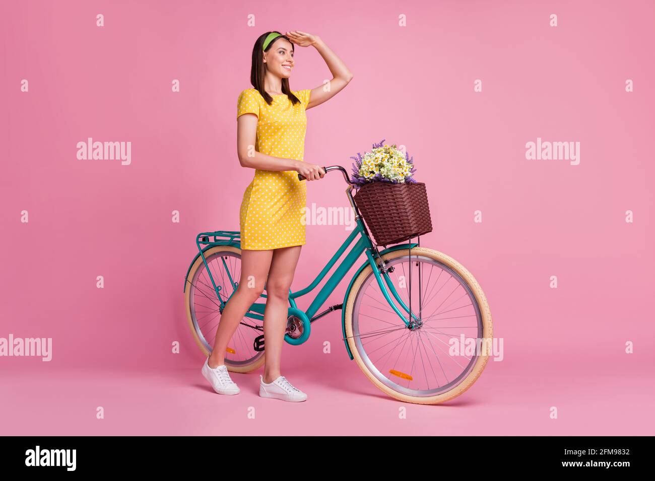 In voller Größe Profil Seitenfoto von jungen schön lächelnd gut Mood Mädchen schauen weit weg halten Fahrrad isoliert auf rosa Farbiger Hintergrund Stockfoto