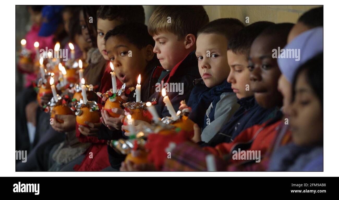 Kinder von der St Barnabas Church of England Schule, Pimlico, machen sich bereit, an den jährlichen Christingle Feiern der Childrens Societys in Westminster Abbey teilzunehmen. Dieses Jahr Thema ist ein Licht auf BullyingThe Orange symbolisiert die Welt, das rote Band das Blut Christi und die Kerze das Licht der Welt. PIC David Sandison 28/11/2002 Stockfoto