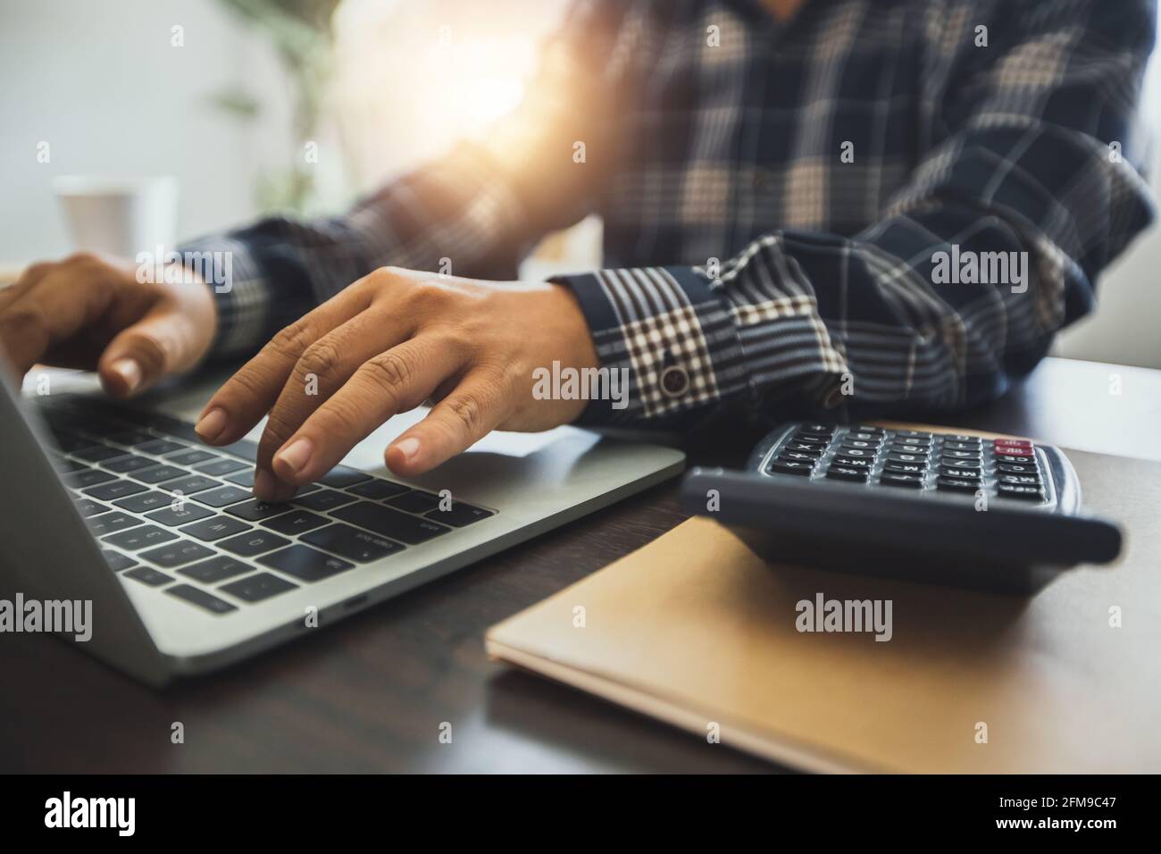 Nahaufnahme Hand des Geschäftsmannes Verwenden Sie Rekordnummer und Finanzbudget auf Laptop nach berechnen mit Rechner, Finanzen und Buchhalter mit Technologie Stockfoto