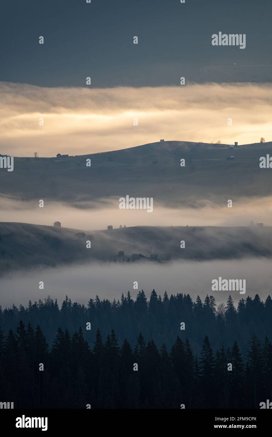 Schöner Sonnenaufgang über Hügeln und Landschaft in den Karpaten. Neblige Morgenlandschaft mit dramatischem Himmel Stockfoto