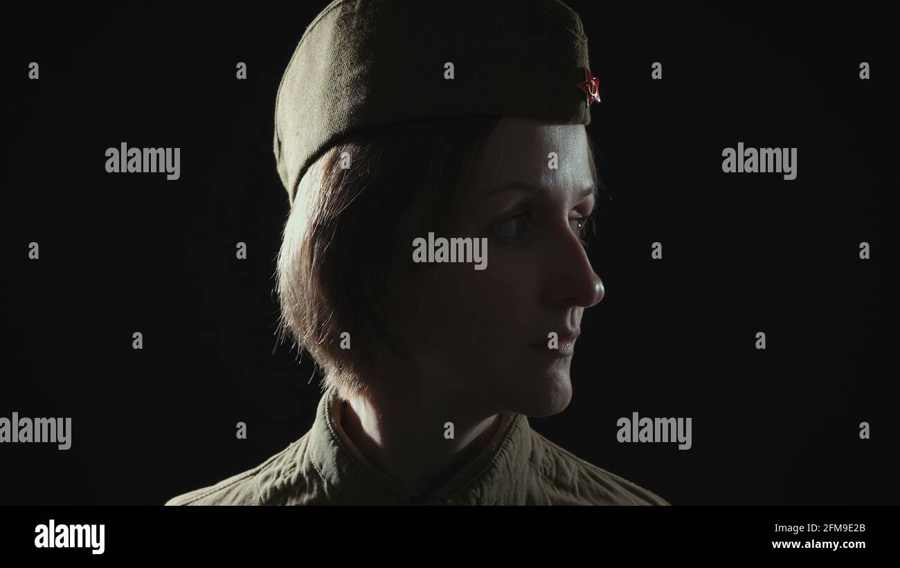 Foto einer Frau, die im Schatten eine sowjetische rote Armeeuniform trägt Stockfoto
