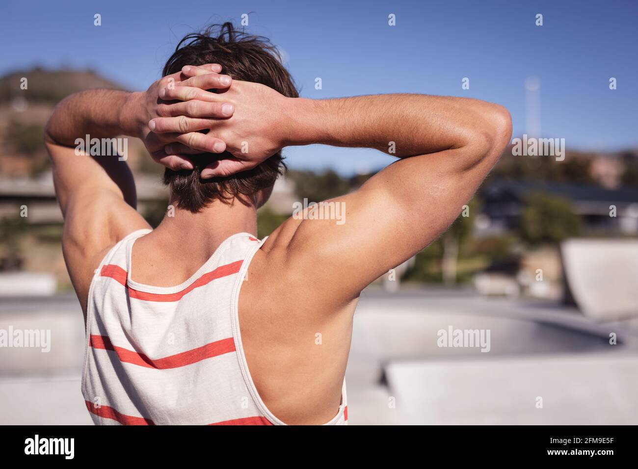 Rückansicht des kaukasischen Mannes, der mit den Händen hinter dem Kopf ruhte Stockfoto