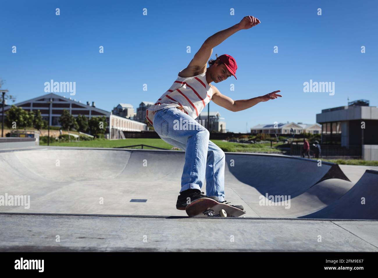Kaukasischer Mann springt und Skateboarding an sonnigen Tagen Stockfoto