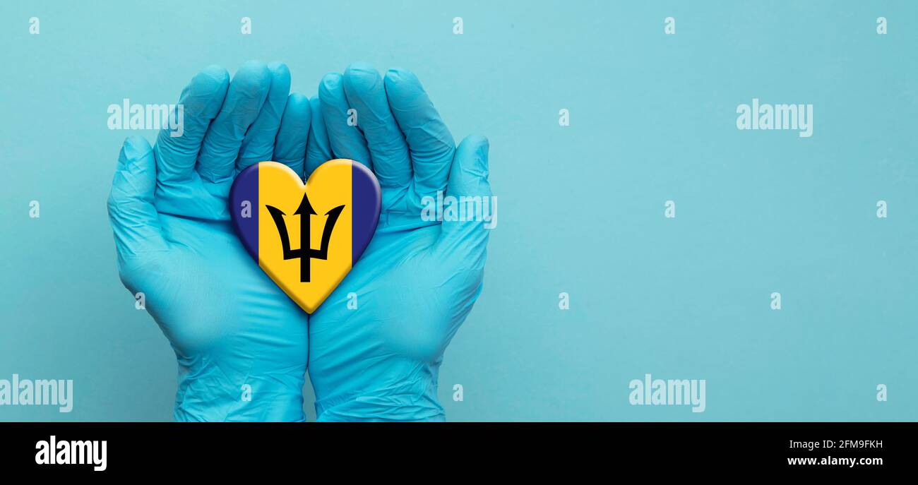 Ärzte Hände tragen chirurgische Handschuhe mit Barbados Flagge Herz Stockfoto