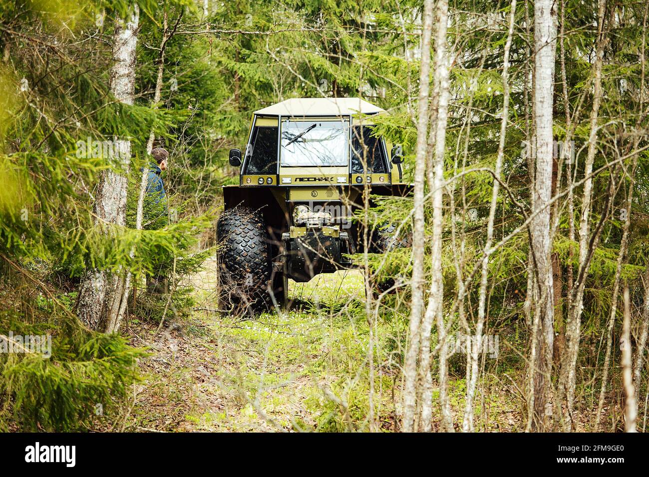 Ein Allradantrieb-Geländewagen fährt durch den Wald durch den Schlamm. Ein passierbarer SUV mit großen Rädern und hoher Durchfahrtshöhe. Spezieller Transpo Stockfoto