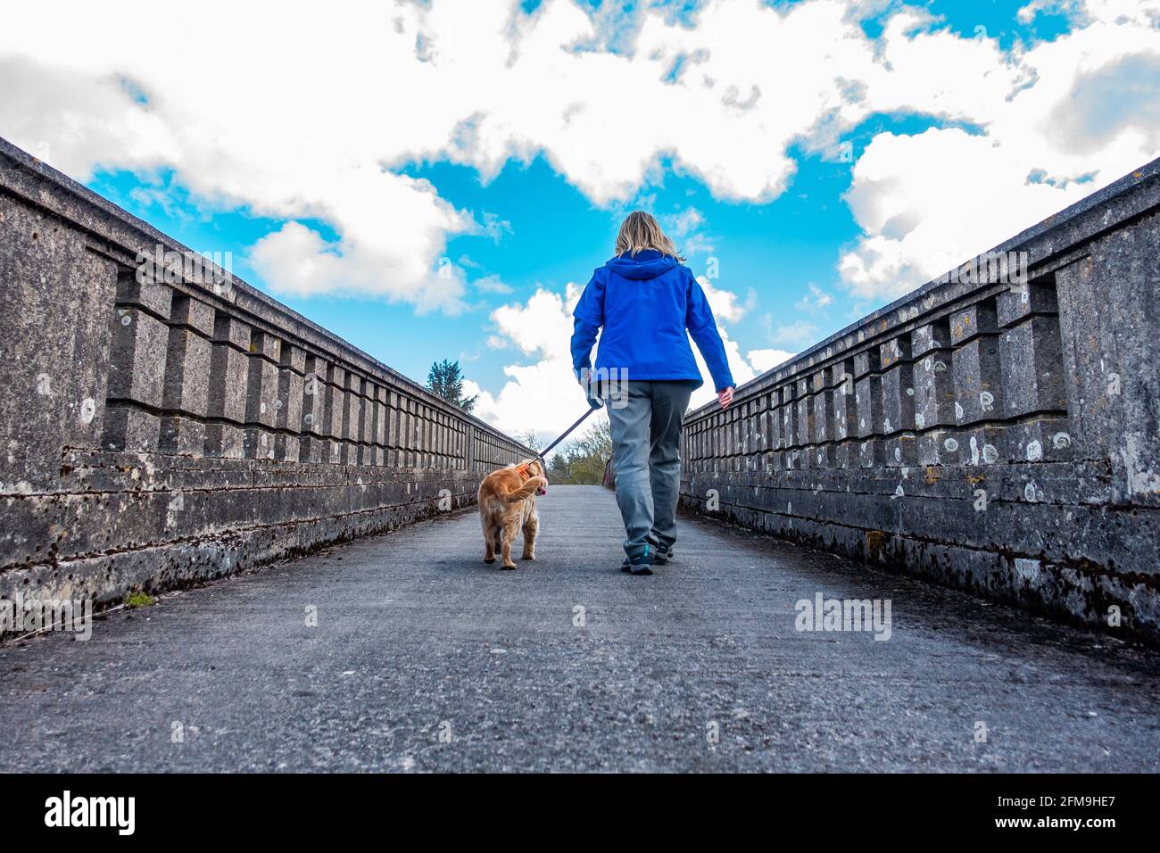 Ein Spaziergänger überquert die Logie Buchan war Memorial Bridge über den Fluss Ythan im kleinen Weiler oder der Gemeinde Logie Buchan, Aberdeenshire, Schottland, Großbritannien Stockfoto