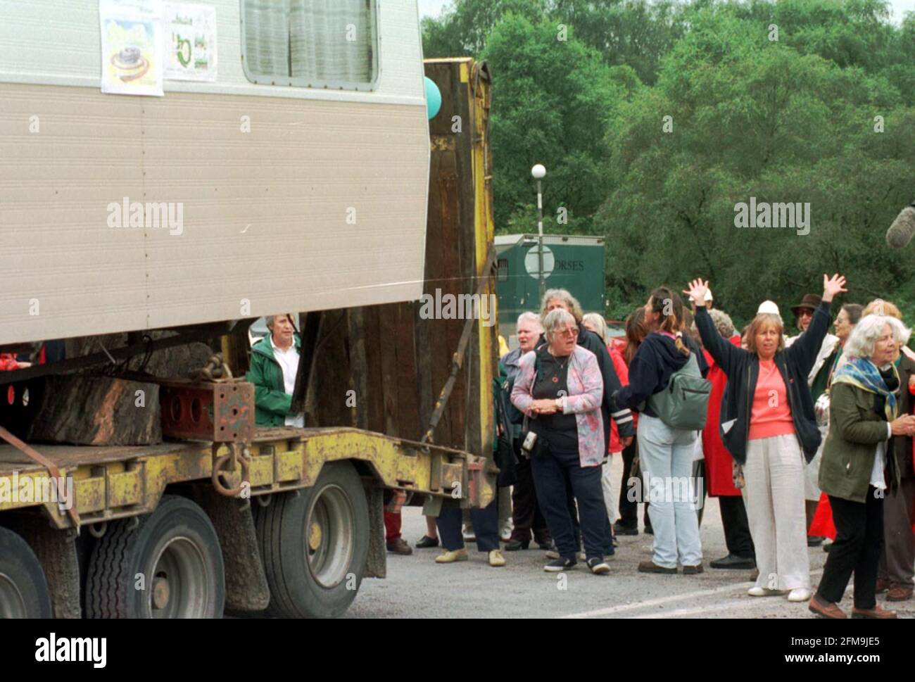 Die Frauen von Greenham Common ziehen nach 19 Jahren endlich weg. Die Frauen winken Auf Wiedersehen zur Karawane, als sie vertrieben wird. Auf der linken Seite mit rosa Jacke ist Jean Hutchinson, und auf der rechten Seite mit Schal ist Sarah Hipper, die beide in der Karawane gelebt haben. 5.9.00 Bild:JOHN VOOS Stockfoto