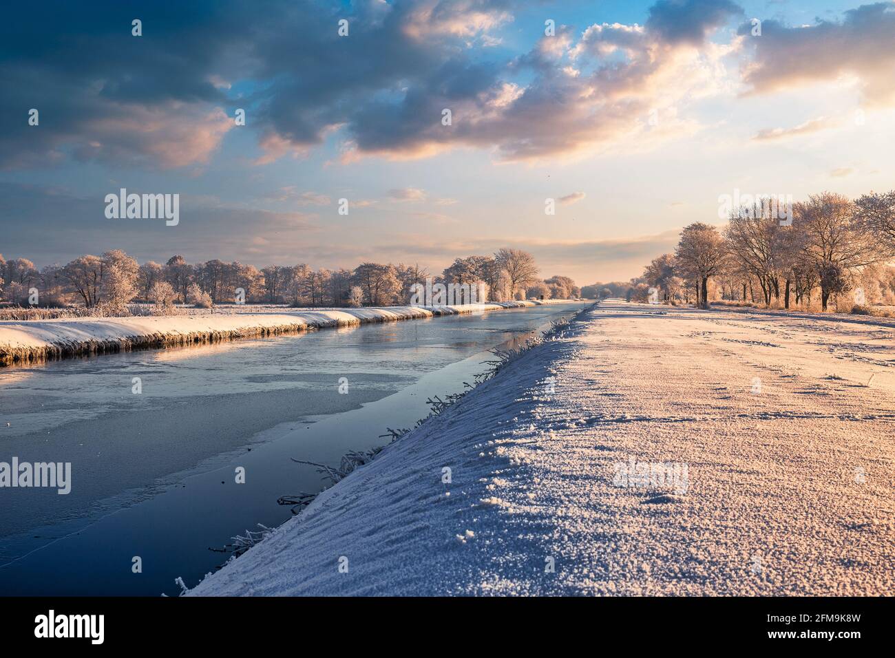 Sonnenaufgang in Wiesmoor, Eastfrisa an einem kalten Wintermorgen mit Schnee und einem bunten Sonnenaufgang. Stockfoto