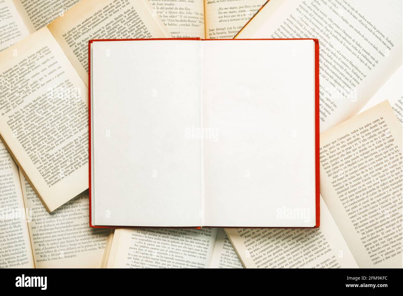 Leeres geöffnetes Buch mit Kopierplatz über andere unfokussierte Bücher Im Hintergrund Stockfoto