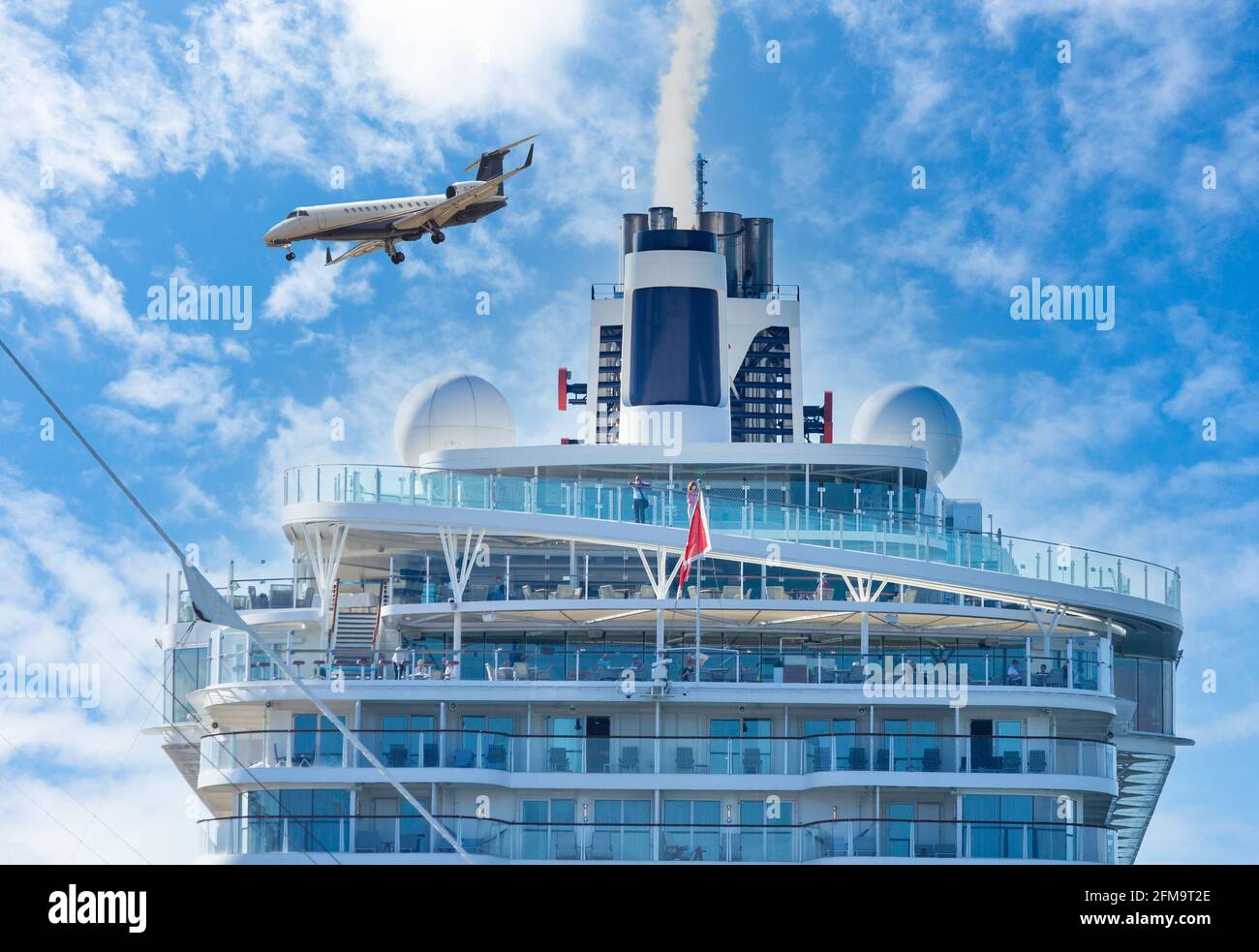 Privatjet, der über dem Kreuzschiff fliegt. Rauch, der aus dem Trichter aufstabt. Globale Erwärmung, Luftfahrt, Schifffahrt, Tourismus... Verschmutzungskonzept. Stockfoto