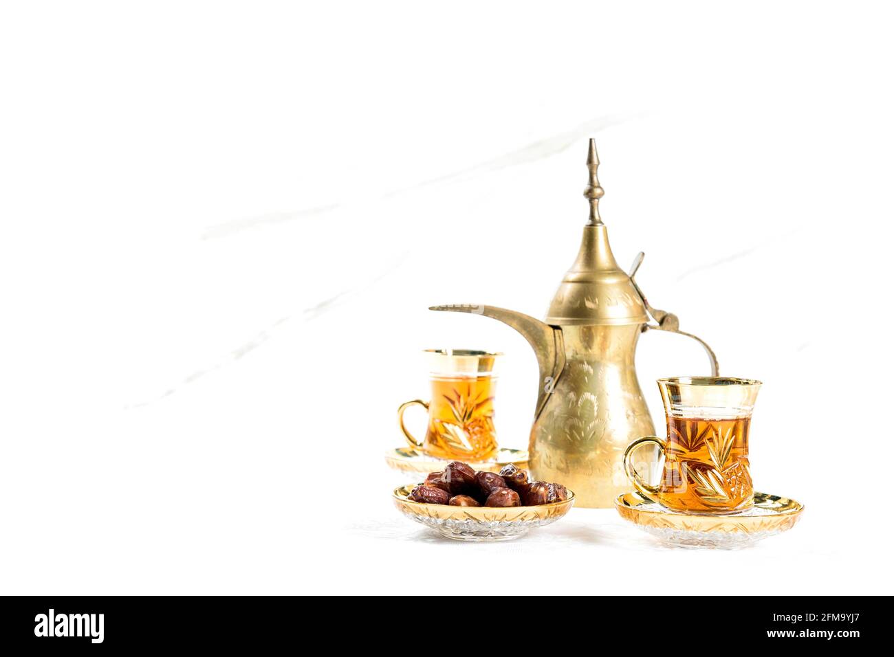 Orientalische Tischdekoration. Teegläser mit Datteln auf weißem Hintergrund Stockfoto