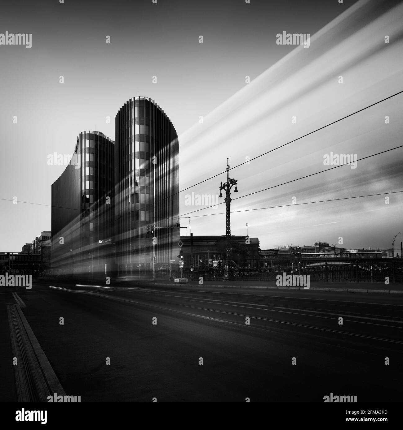 Fahrende Straßenbahn am Bürogebäude in der Berliner Friedrichstraße in Schwarz-Weiß. Stockfoto