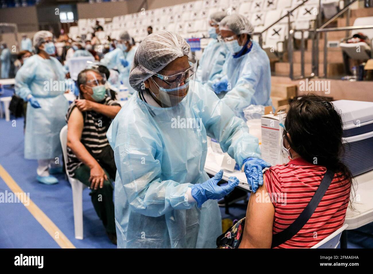 Im Makati Coliseum in der Metropole Manila impfen Gesundheitshelfer Einwohner mit dem russischen Impfstoff Sputnik V COVID-19. Die Philippinen erhielten die ersten 15,000 Dosen von Sputnik V, die vom russischen Gamaleya-Institut entwickelt wurden, und wurden in vier Städten der Hauptstadtregion für ein gleichzeitiges Impfprogramm verteilt. Manila, Philippinen. Stockfoto