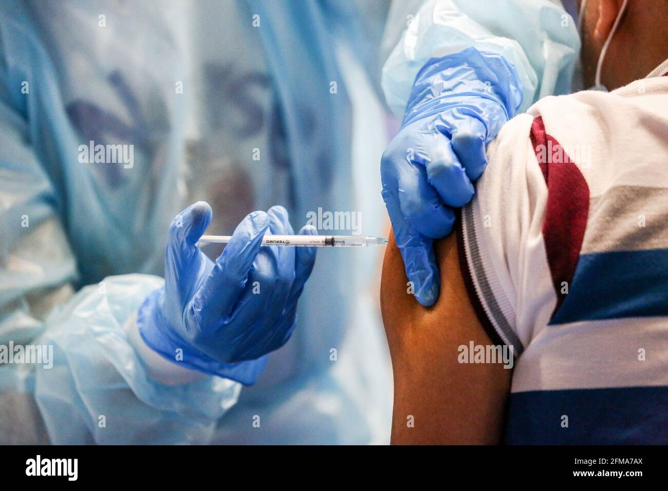 Im Makati Coliseum in der Metropole Manila impfen Gesundheitshelfer Einwohner mit dem russischen Impfstoff Sputnik V COVID-19. Die Philippinen erhielten die ersten 15,000 Dosen von Sputnik V, die vom russischen Gamaleya-Institut entwickelt wurden, und wurden in vier Städten der Hauptstadtregion für ein gleichzeitiges Impfprogramm verteilt. Manila, Philippinen. Stockfoto