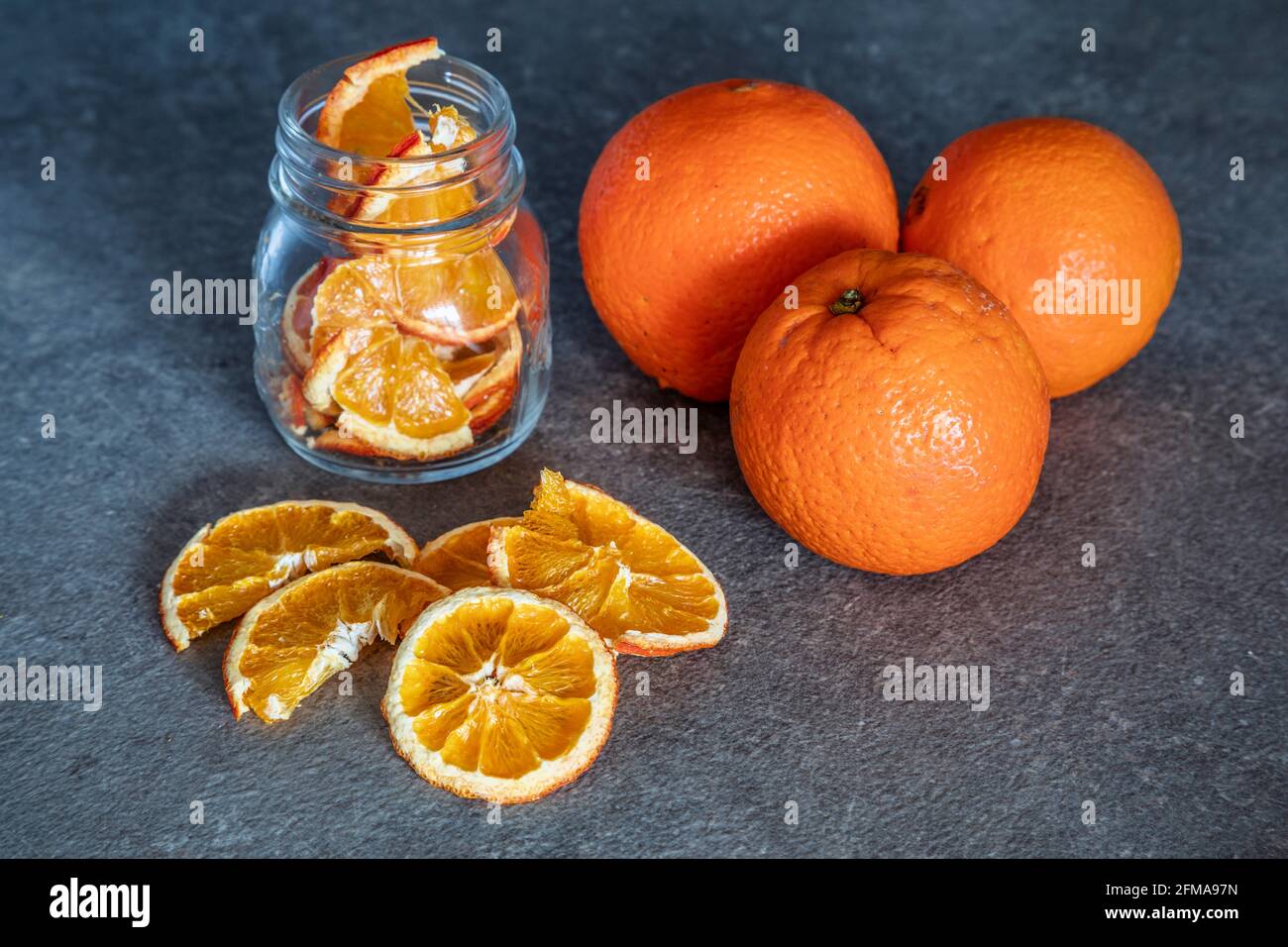 Frisches Obst Orangen und Orangenscheiben dehydriert und in Glasbehältern gelagert, hausgemachte Zubereitungen, Stockfoto