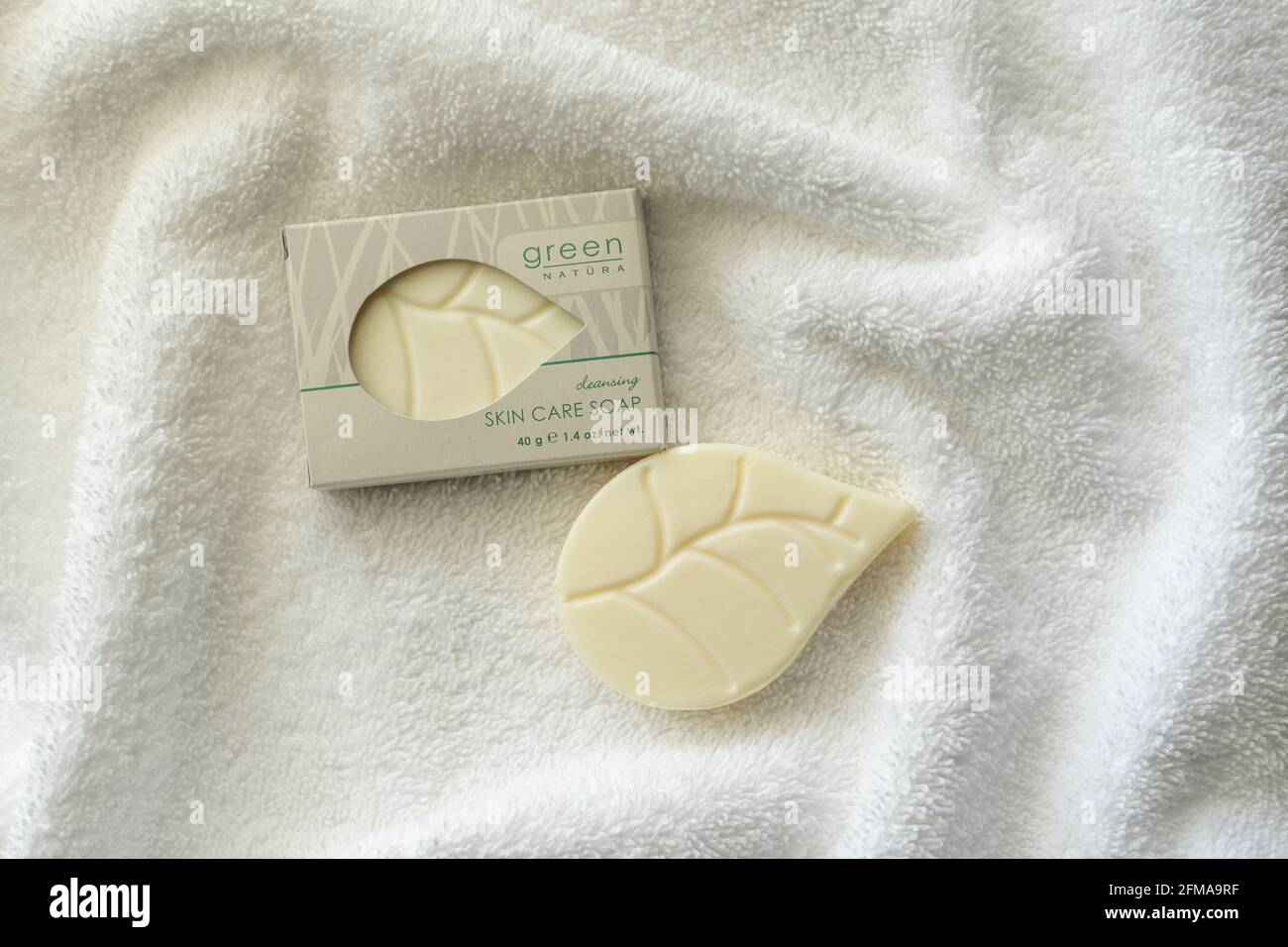 Little Switzerland, NC - 22. April 2021: Umweltfreundliche Hotelausstattung Green Natura Seife in der Box und auf einem weißen Frottee-Handtuch sitzend Stockfoto