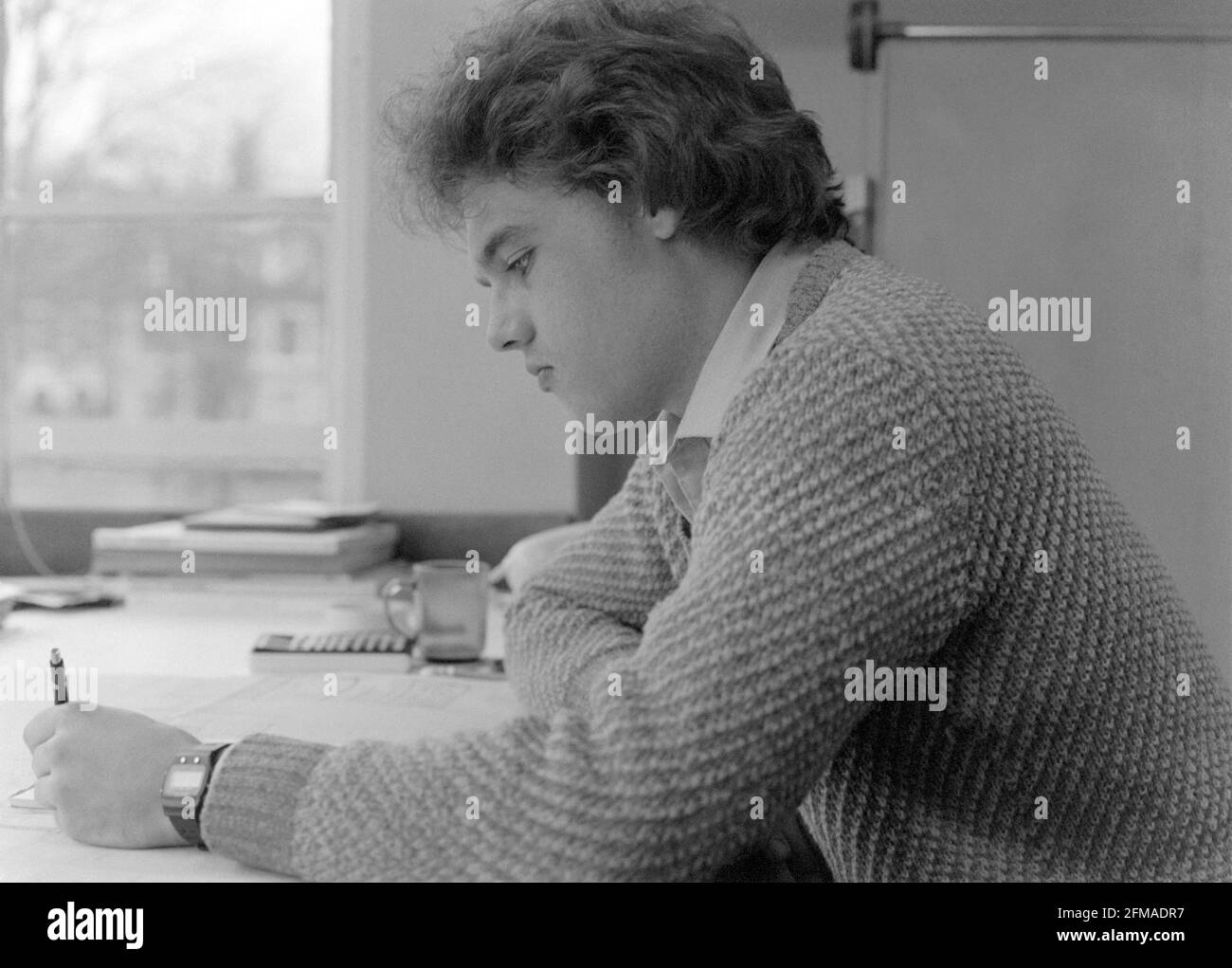 Junger Mann, der Ende der 70er Jahre an seinem Schreibtisch arbeitete, england Stockfoto