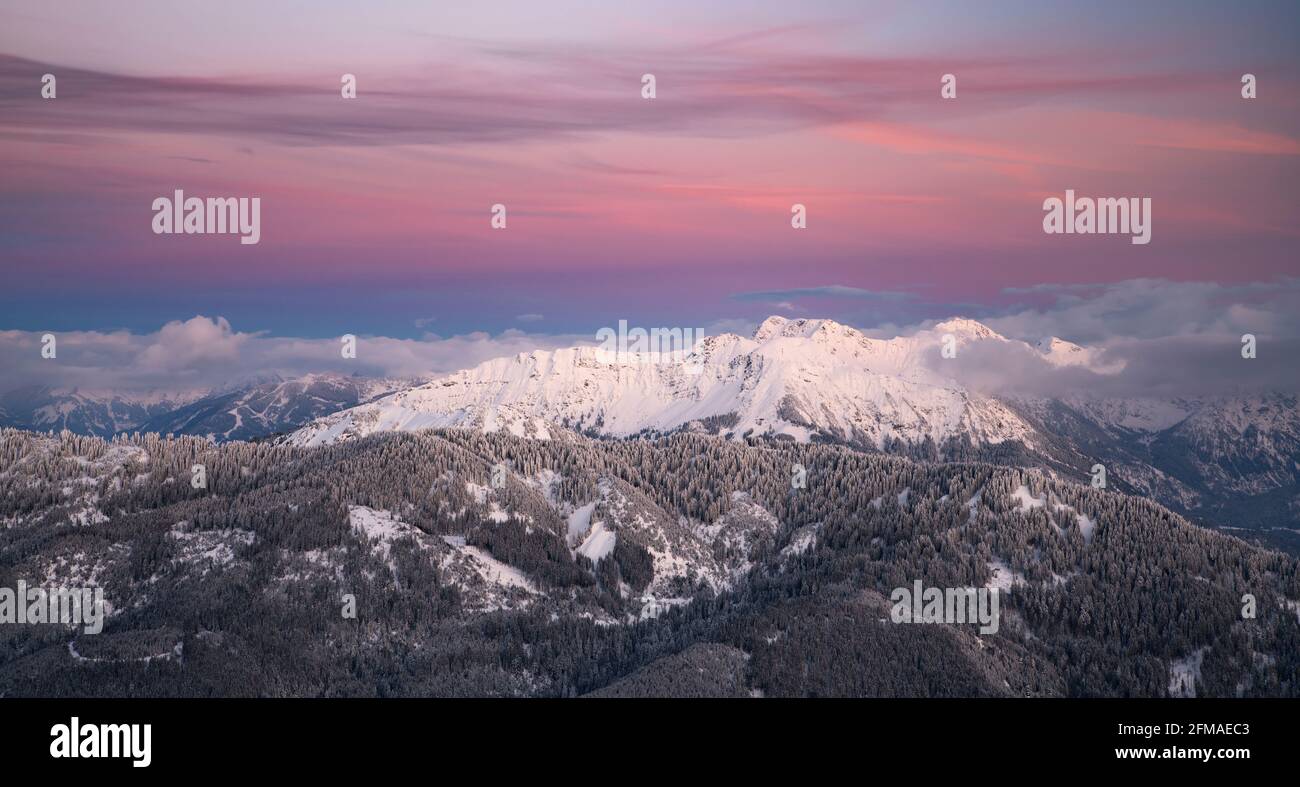 Winterlich verschneite Berglandschaft nach Sonnenuntergang. Bunte Wolken über Kühgundkopf und Iseler. Allgäuer Alpen, Bayern, Deutschland, Europa Stockfoto