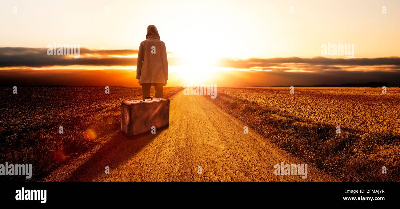 Junge Frau mit Koffer bei Sonnenuntergang Stockfoto
