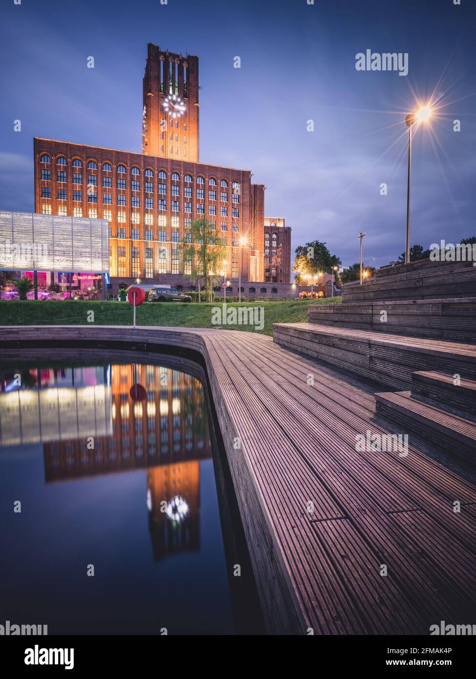 Blaue Stunde im beleuchteten Ullsteinhaus in Berlin mit Reflexion im Tempelhof-Hafen. Stockfoto