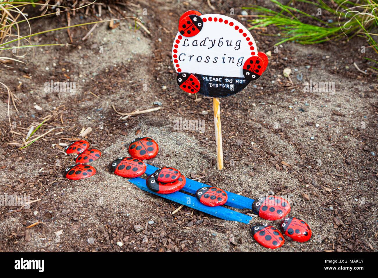 Kinderladybird-Kunstinstallation in einem öffentlichen Park mit Blumenbeet Steveston British Columbia, Kanada Stockfoto