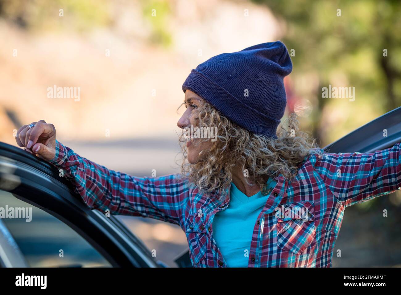 Hipster fröhliches Porträt der kaukasischen jungen Frau lächeln und genießen Reisen Stehen vor dem Auto mit unschärfem Hintergrund - Menschen Und transportieren gesunde Outdoor-Freizeitaktivitäten Stockfoto