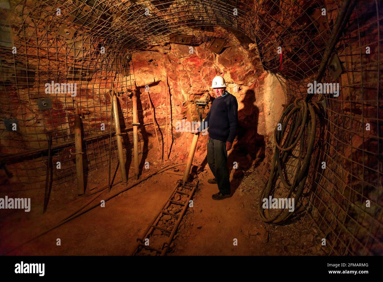 Tennant Creek, Australien - 2019. August: Ehemaliger Bergmann zeigt Bergbauwerkzeuge während der Führung in der Goldmine Battery Hill unter Tage. Alter Bergbau Stockfoto
