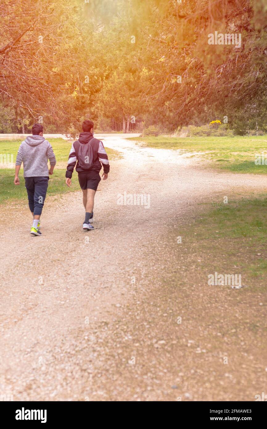Zwei junge Teenager, die auf einem ländlichen felsigen Pfad spazieren Ein sonniger Abend Wanderkonzept selektiver Fokus Stockfoto