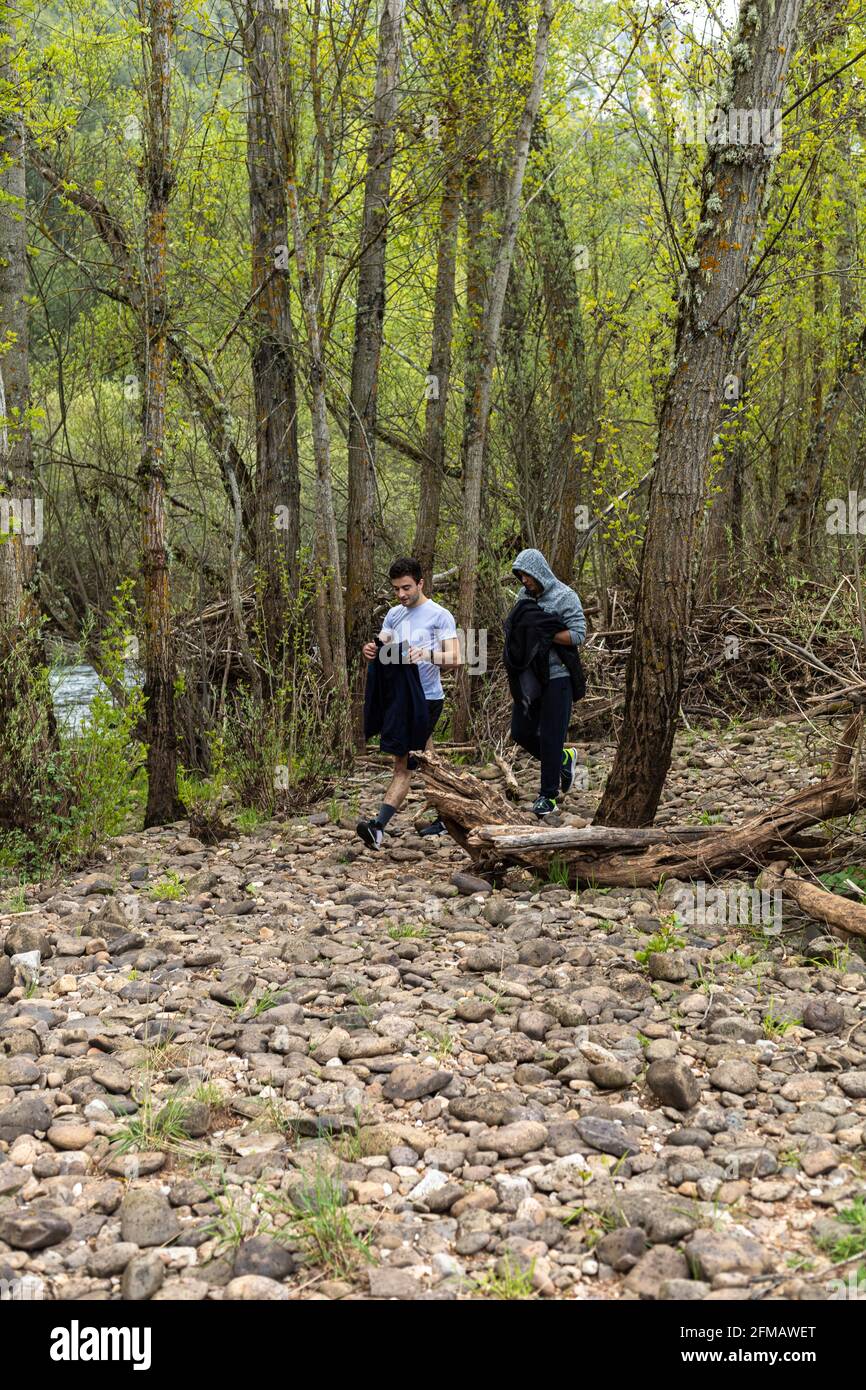 Zwei junge Teenager wandern auf dem Land neben einem Bach und Bäume mit selektivem Fokuskonzept Wandern Gesundheit Natur Stockfoto