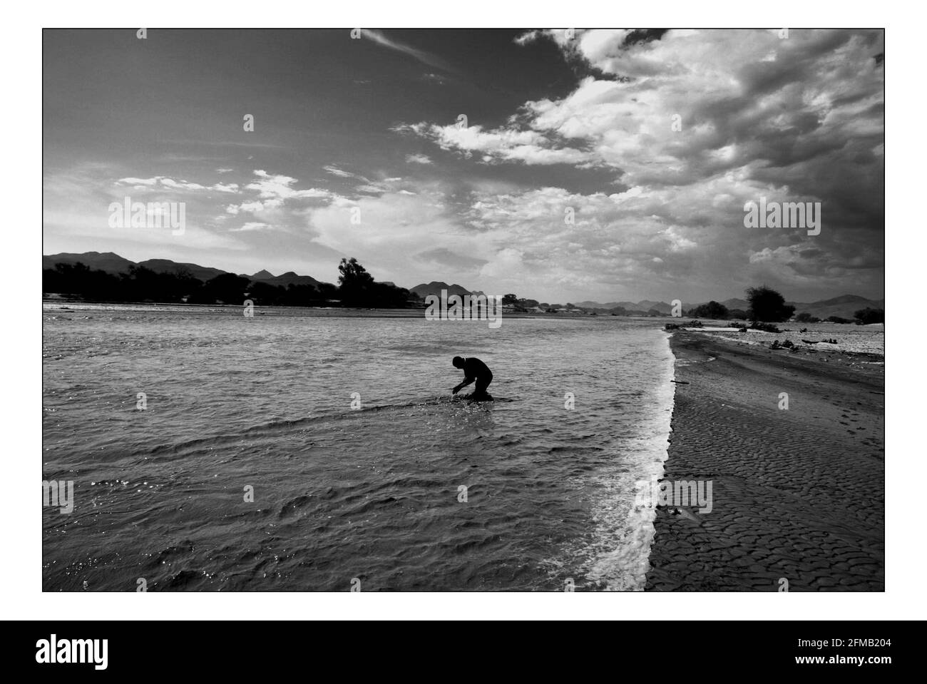 Unabhängiger Weihnachtsschmuck...... Integrierte ländliche Entwicklung und Naturschutz (IRDNC) in Namibia die trockene Wüstenlandschaft Namibias wartet auf die ersten Regenfälle der Saison. Ein klarer, bakeing blauer Himmel wird langsam in ein tiefes Dunkelgrau gekocht, während die Wolken sich einrollen. Der Regen stürmt und sobald knochentrockene Flüsse zum Leben erwacht. Der Horaseb River am Tag nach den ersten Regenfällen der Saison. Foto von David Sandison November 2004 Stockfoto