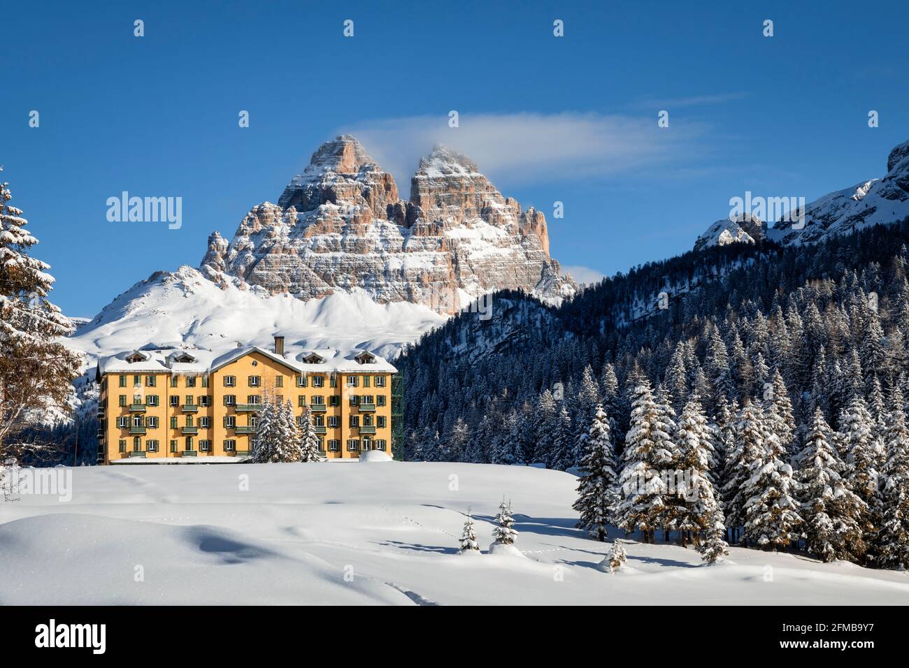 Misurina im Winter, das Institut „Pio XII“ - Zentrum für die Behandlung und Rehabilitation von Atemwegserkrankungen bei Kindern, im Hintergrund die Südwand der Tre Cime di Lavaredo, Dolomiten, Auronzo di Cadore, Belluno, Venetien, Italien Stockfoto