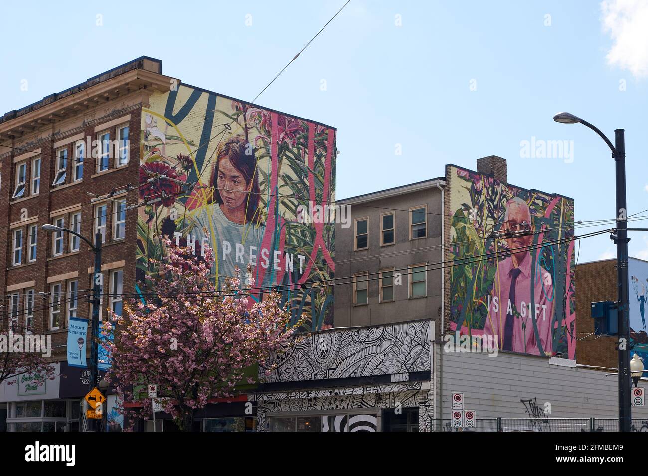 Architektur und großes Wandgemälde, das auf der Seite eines alten Gebäudes während des Vancouver Mural Festivals in Mount Pleasant, Vancouver, BC, Kanada, gemalt wurde Stockfoto