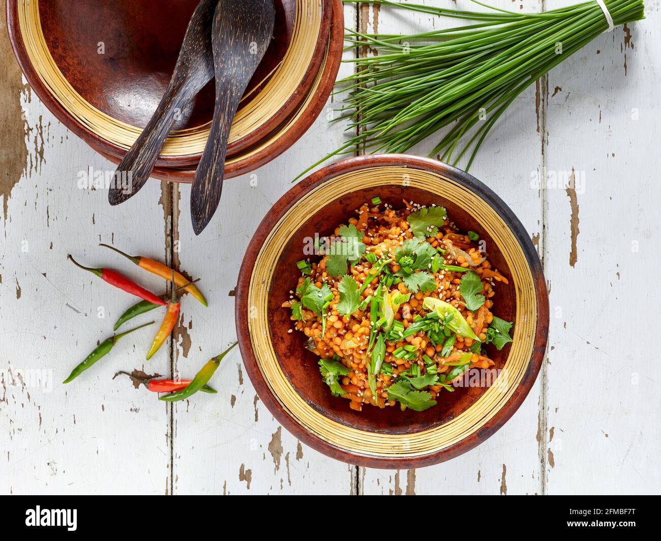 Ayurvedische Küche – Linsensalat in Tongerichten mit Schnittlauch und Chilischoten Stockfoto