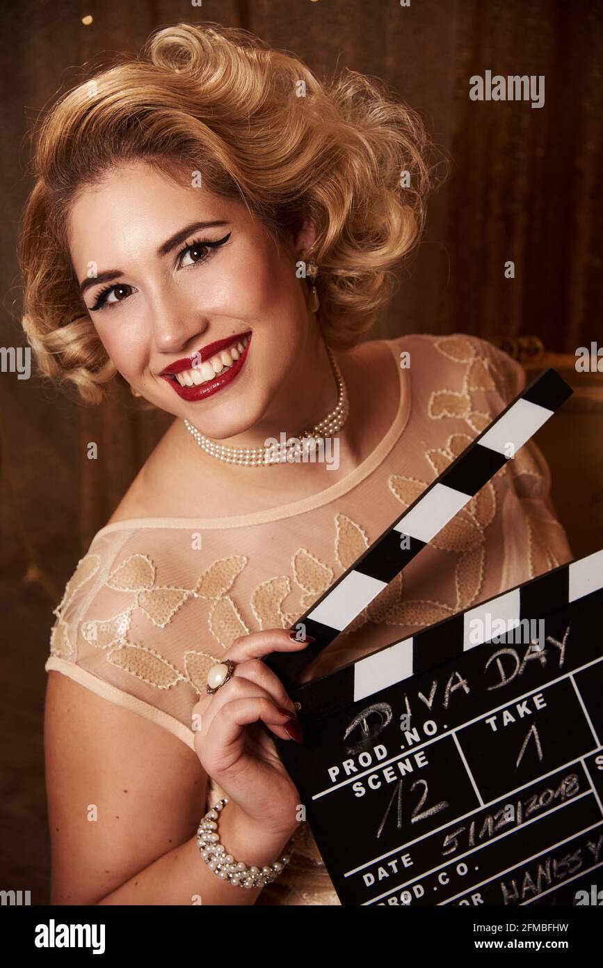 Junge Frau mit blondem Haar im Marilyn Monroe-Stil mit Klappbrett Stockfoto