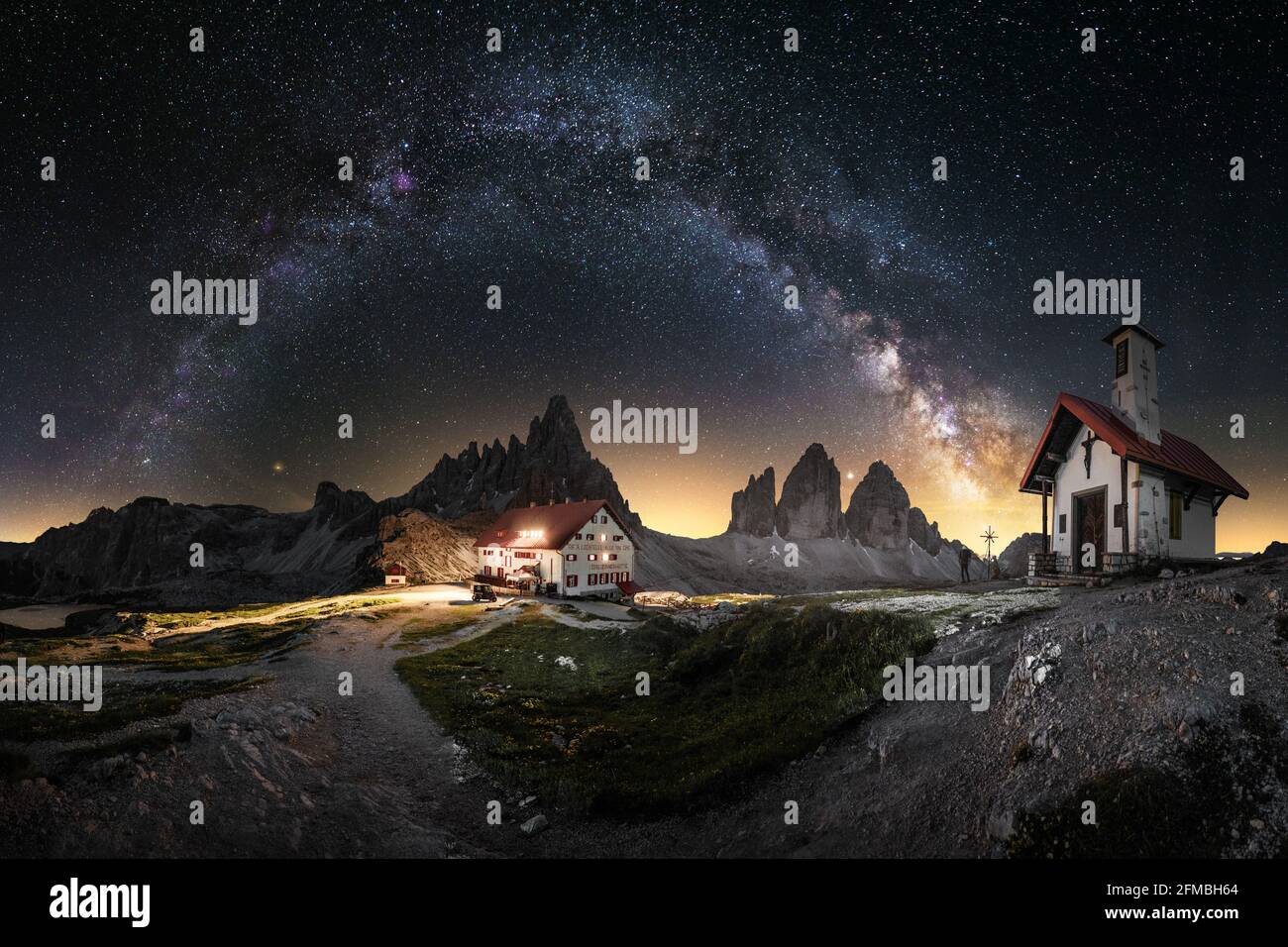 Nachtaufnahme mit einer Kirche und Blick auf die berühmten 3 Zinnen in den Dolomiten. Stockfoto
