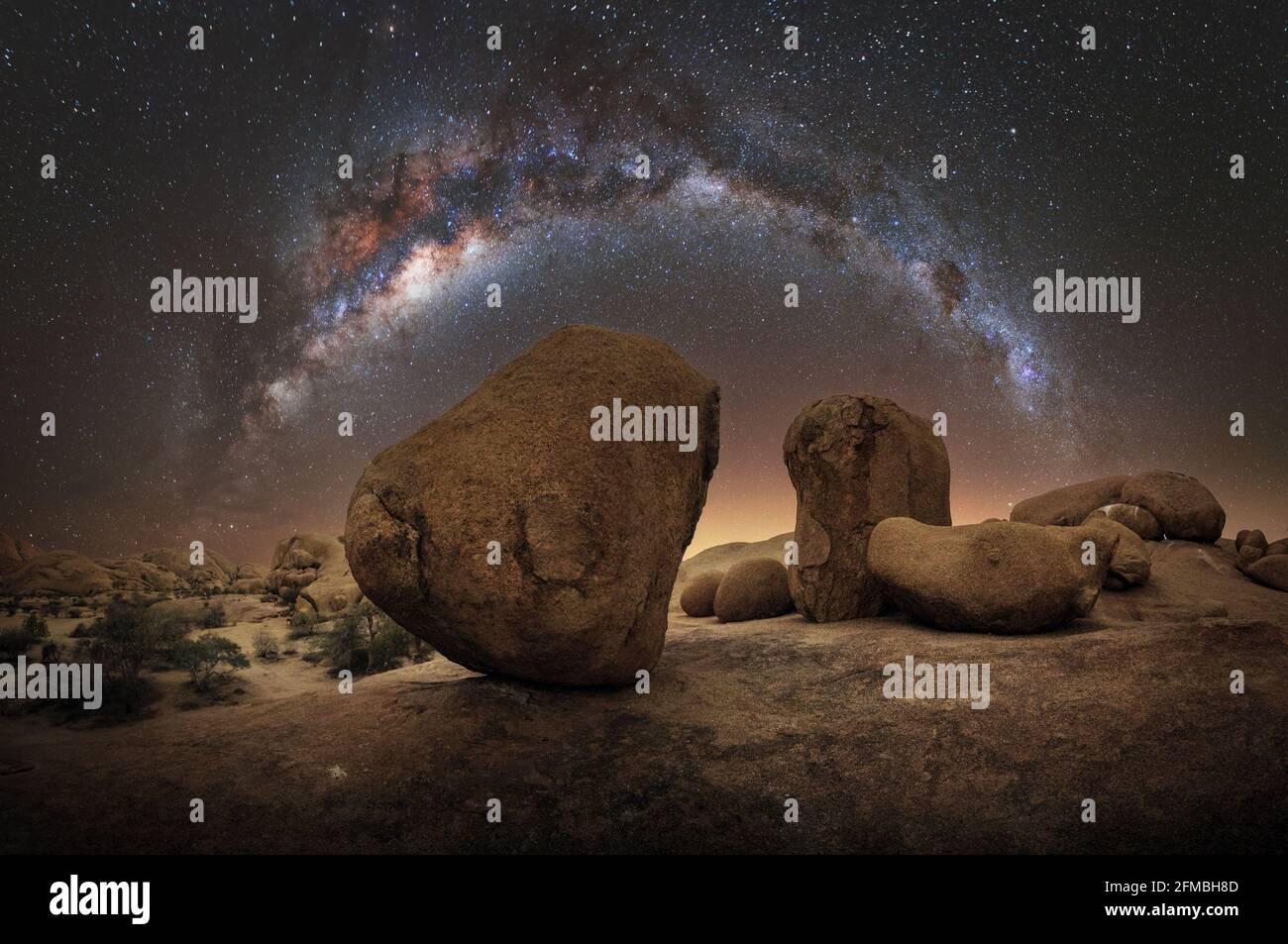 Nachtaufnahme mit Milchstraße über abstrakten Felsen in Namibia. Stockfoto