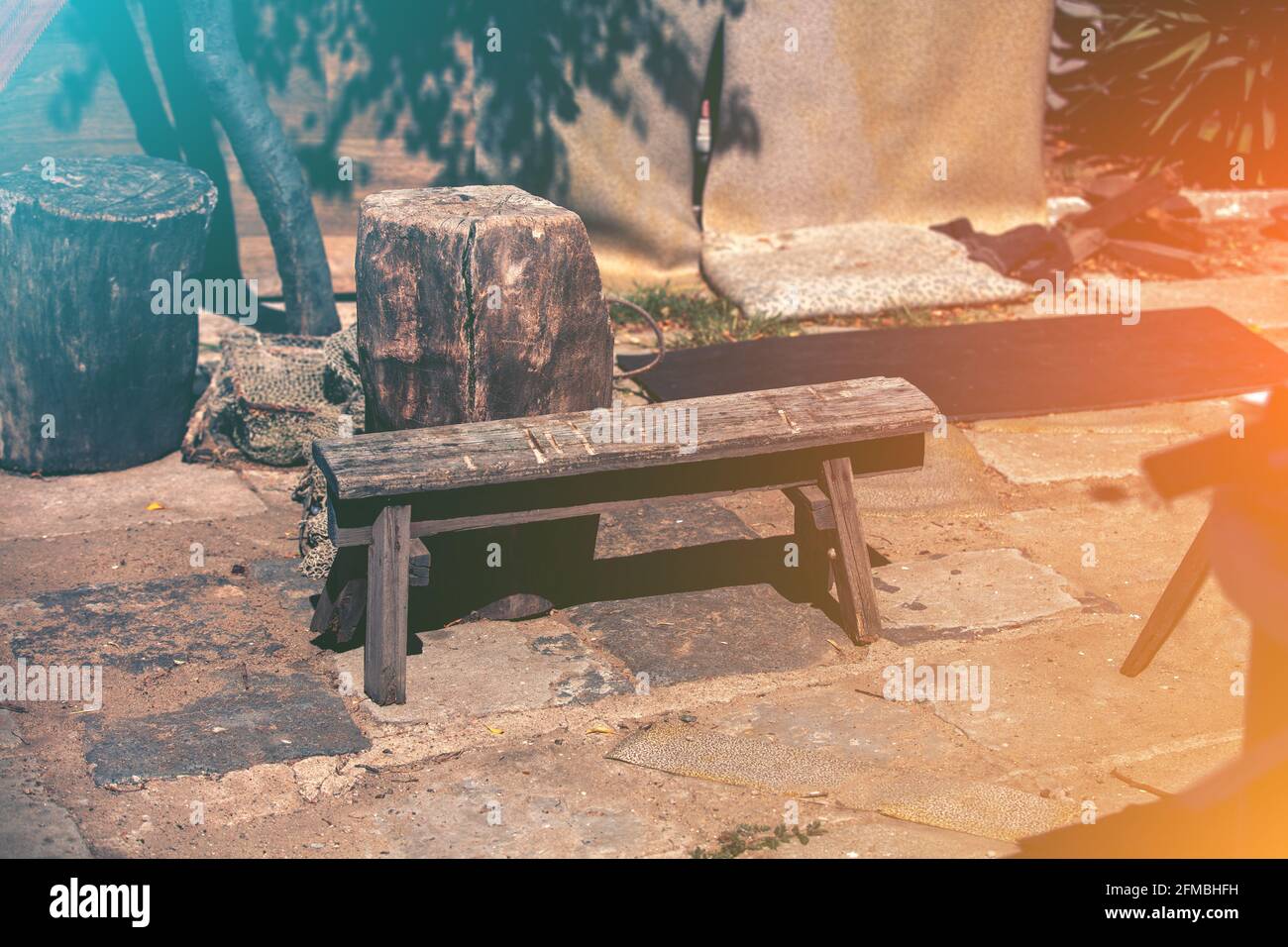 Holzbank und Beistelltisch aus Holz im Hof. Künstlerisches Licht Stockfoto
